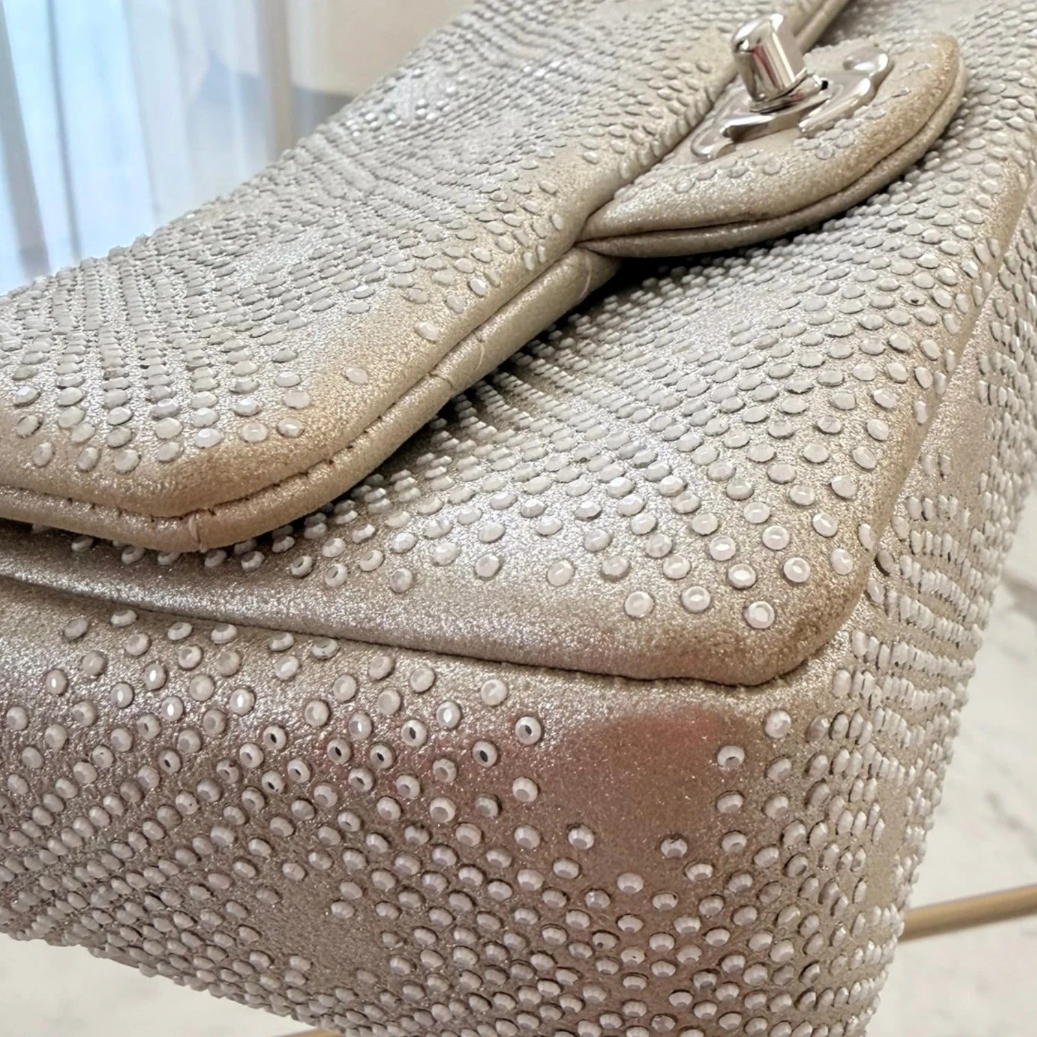 Close-up of a Chanel iridescent studded calfskin Mini Flap crossbody bag, with a chain strap and silver hardware available in Cyprus at HOUSE of MICY