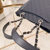 Back pocket and handles of a Chanel Caviar Grand Shopping Tote bag, blue caviar leather, with chain handles, silver hardware available in Cyprus at HOUSE of MICY